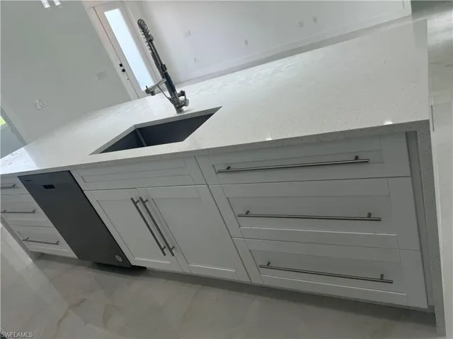Details with white cabinets and light stone countertops