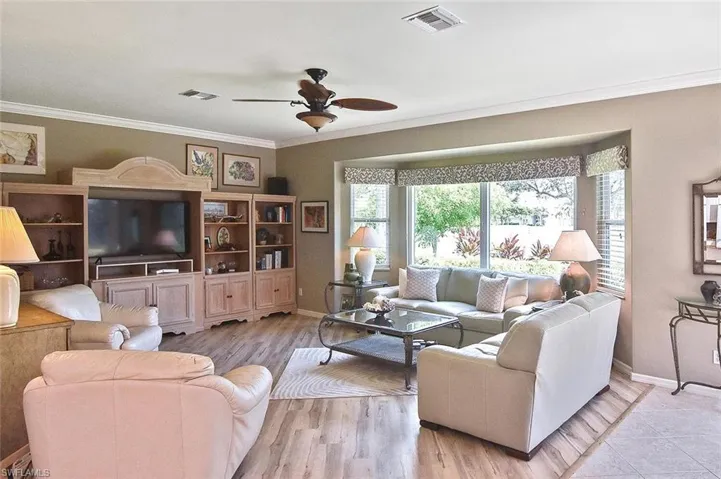 Living area featuring crown molding, ceiling fan, and wood finished floors