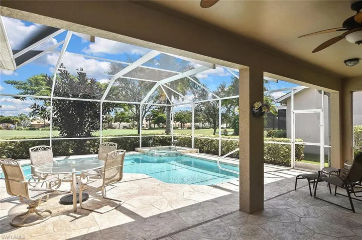 View of swimming pool featuring a ceiling fan, a patio, and a pool with connected hot tub