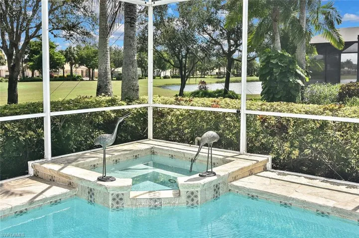 Swimming pool with an in-ground hot tub and a water view