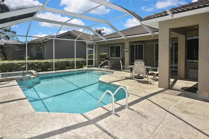 View of swimming pool with a patio area, a pool with connected hot tub, a ceiling fan, and a lanai