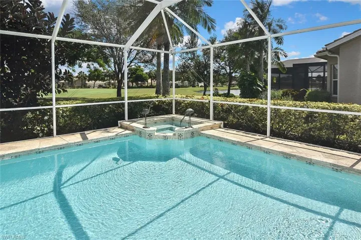 View of pool with a pool with connected hot tub and a lanai
