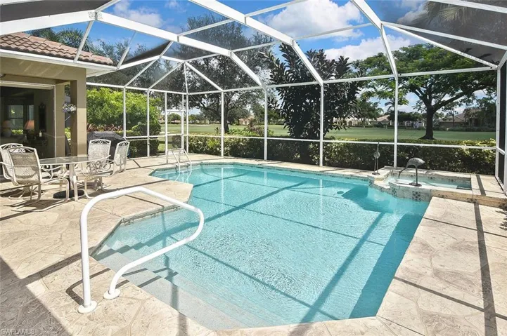 View of pool featuring a patio area, a pool with connected hot tub, and a lanai