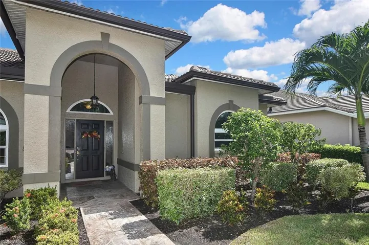 Property entrance with a tiled roof and stucco siding