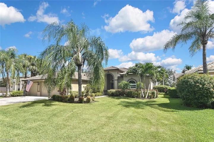 Mediterranean / spanish-style house with stucco siding, driveway, and a front lawn