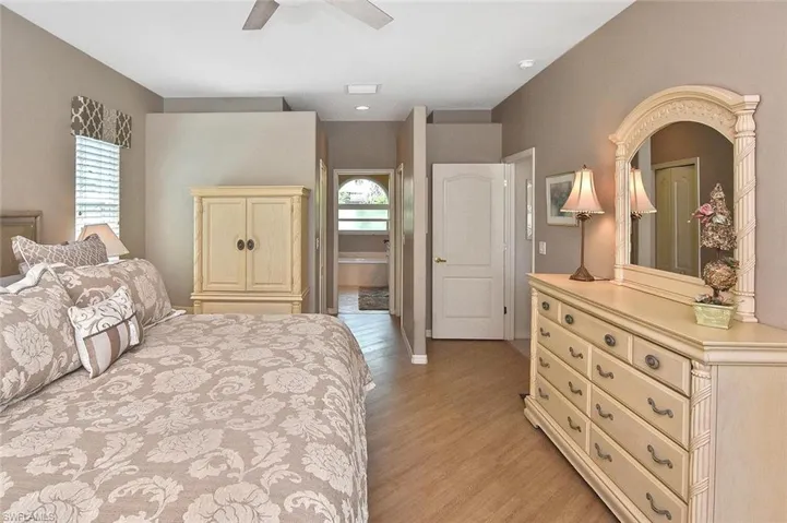 Bedroom featuring multiple windows, light wood-style floors, and a ceiling fan