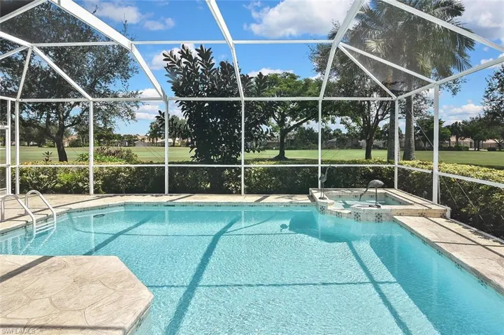 View of pool featuring a lanai, a pool with connected hot tub, and a patio