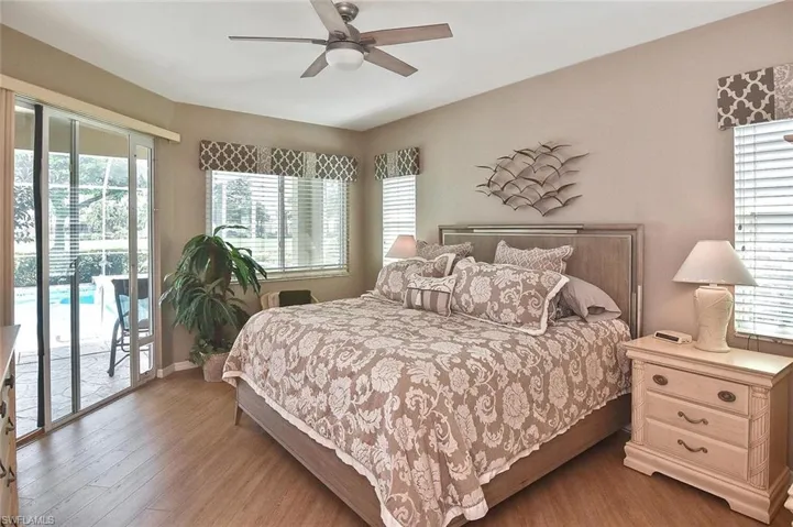 Bedroom with access to exterior, wood finished floors, and ceiling fan