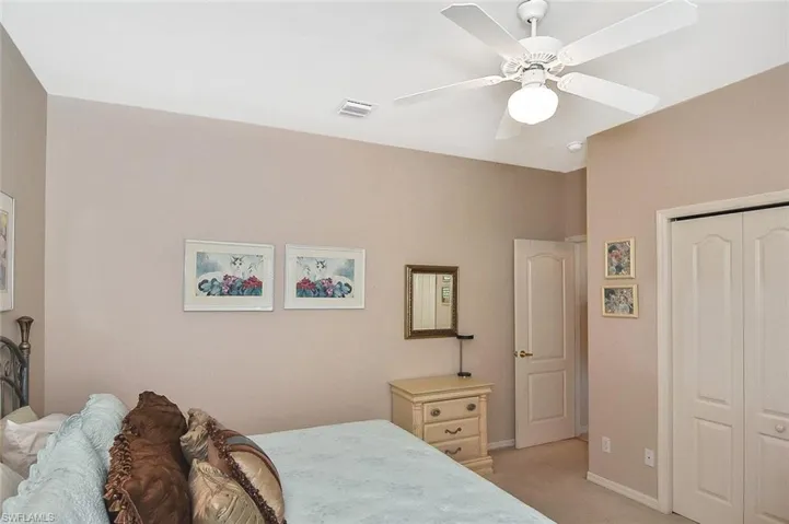 Bedroom with light carpet, a closet, and ceiling fan