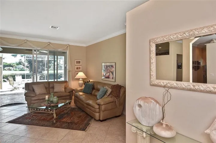 Living area featuring ornamental molding and tile patterned flooring