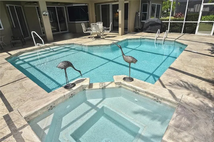 View of swimming pool featuring a ceiling fan, a patio area, and a pool with connected hot tub