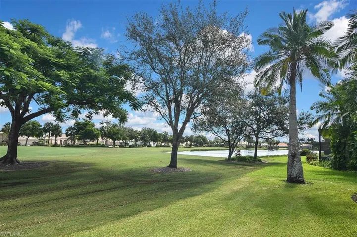 View of community with a water view, a yard, and view of golf course