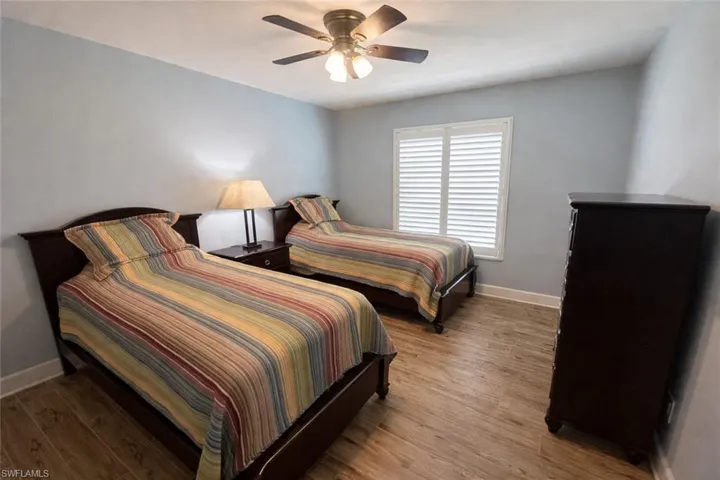 Guest Bedroom with wood finished floors and a ceiling fan