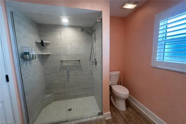 Primary Bathroom with wood finish floors and a shower stall
