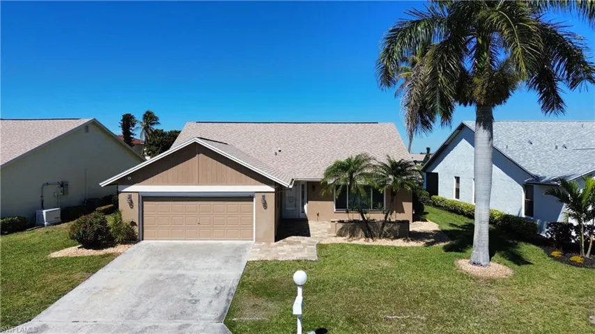 Ranch-style home with a front lawn, a garage, concrete driveway, stucco siding, and a shingled roof