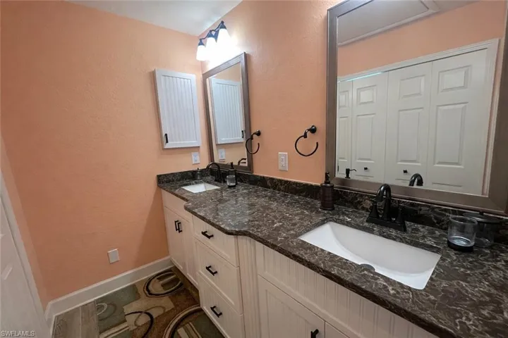 Primary bath Full bath with a textured wall and double vanity