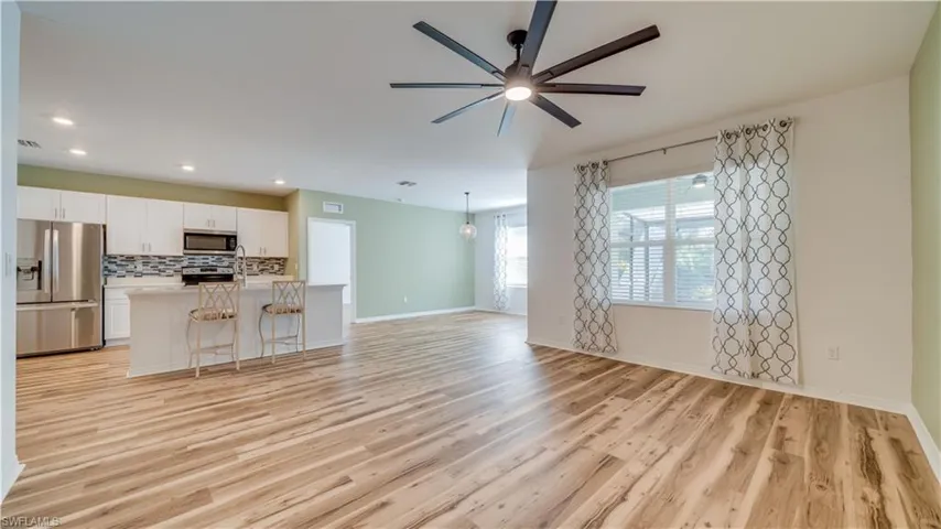 Unfurnished living room featuring a ceiling fan and light wood-style flooring