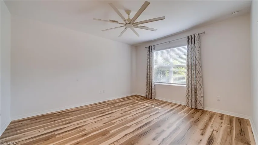 Spare room with light wood finished floors and a ceiling fan