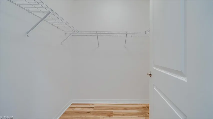 Spacious closet with light wood finished floors