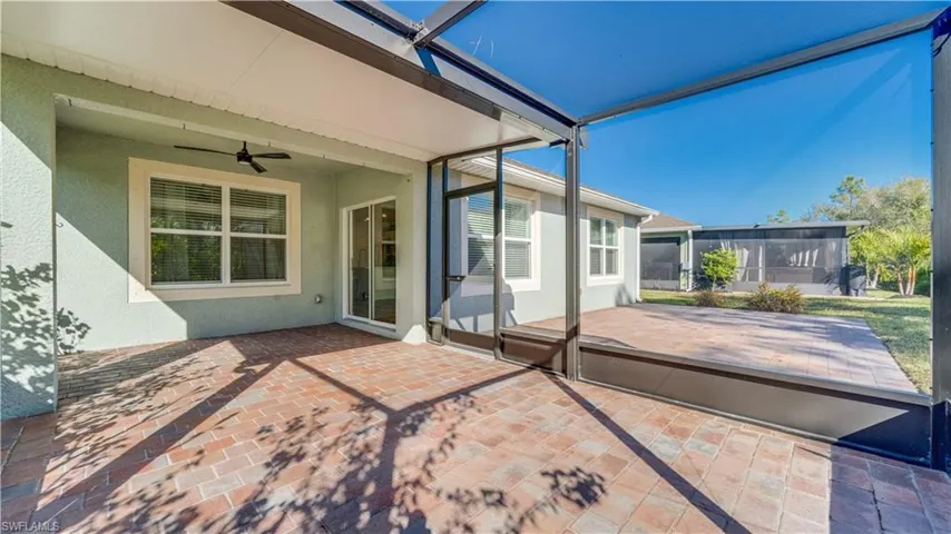 Unfurnished sunroom with ceiling fan and a patio area