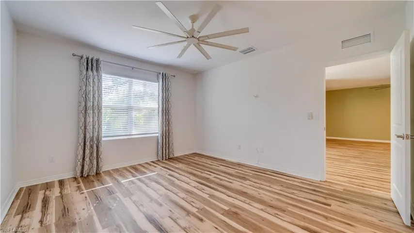 Unfurnished room featuring ceiling fan and light wood-style floors