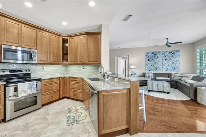 Kitchen with a breakfast bar, visible vents, appliances with stainless steel finishes, a sink, and a peninsula