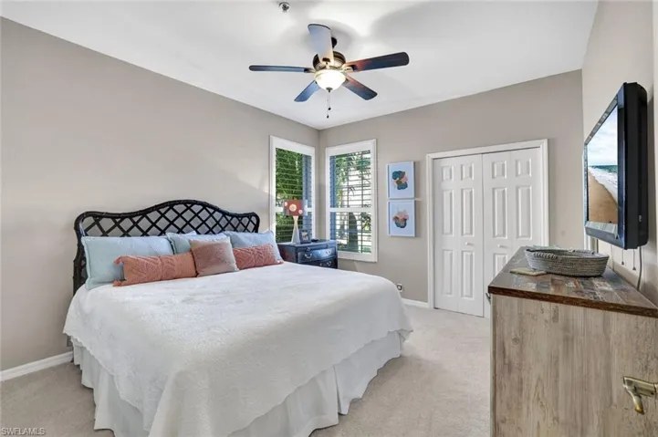 Bedroom with baseboards, a closet, a ceiling fan, and light colored carpet
