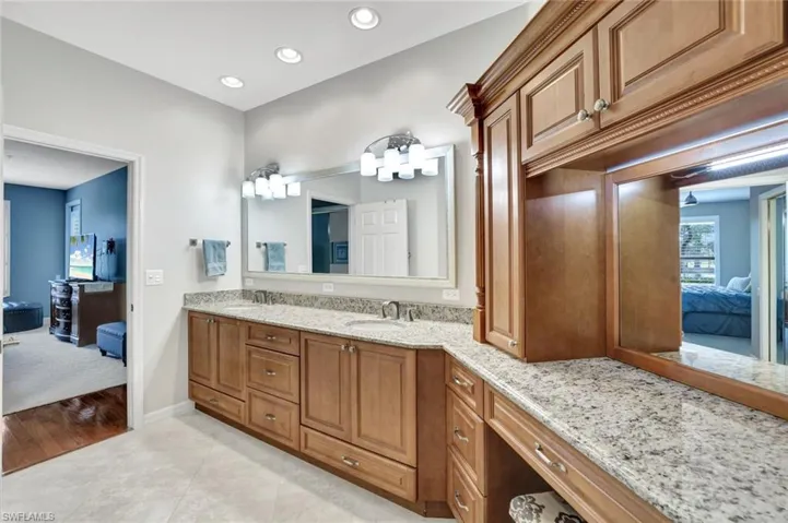 Ensuite bathroom featuring connected bathroom, recessed lighting, a sink, tile patterned floors, and double vanity