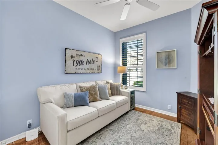 Living area with ceiling fan, wood finished floors, and baseboards