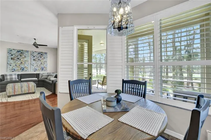 Dining area with a wealth of natural light and ceiling fan with notable chandelier
