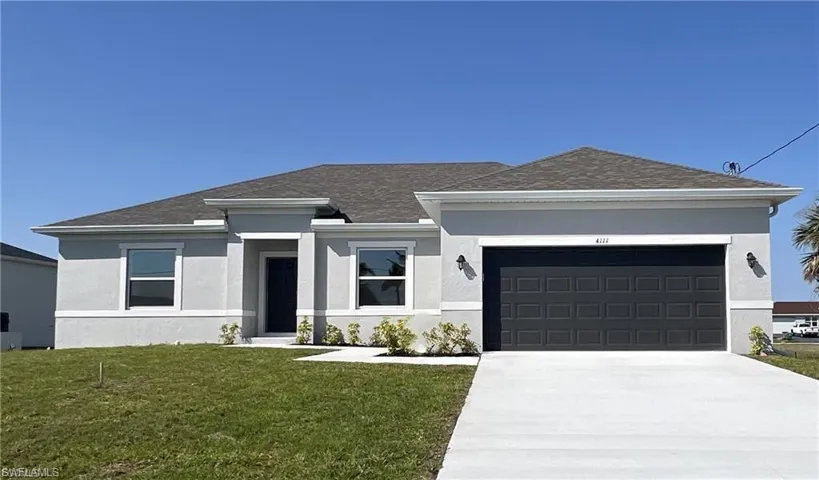 Prairie-style house with a front yard, stucco siding, concrete driveway, an attached garage, and roof with shingles