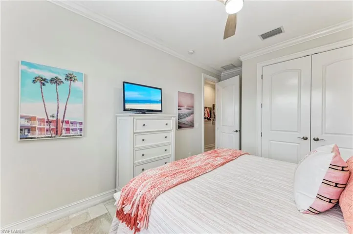 Bedroom featuring a closet, ceiling fan, and crown molding