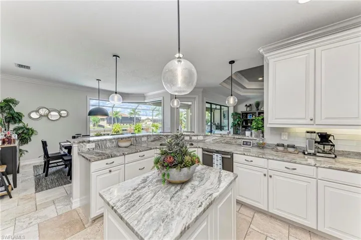 Kitchen with white cabinetry, pendant lighting, kitchen peninsula, and a center island