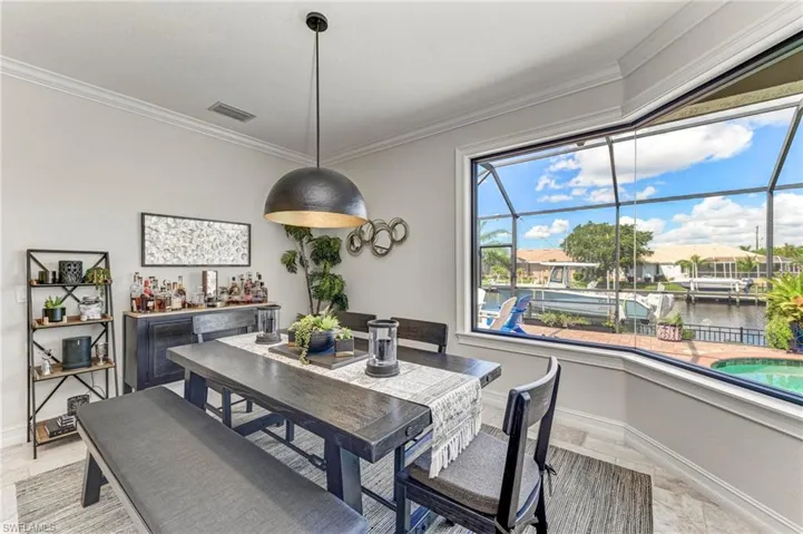 Dining room with ornamental molding, a water view, and a healthy amount of sunlight