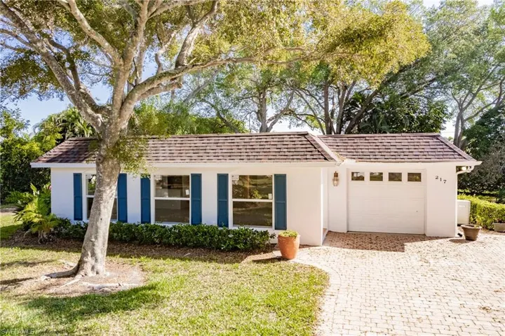 Ranch-style home with a garage, stucco siding, decorative driveway, and a shingled roof