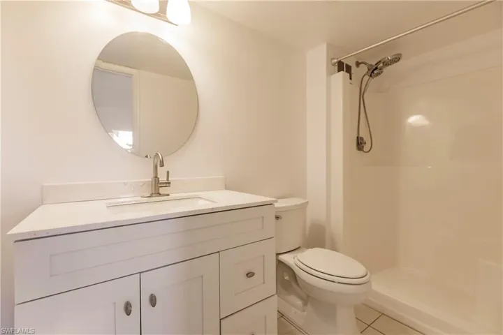 Full bathroom featuring vanity, tile patterned flooring, and a shower