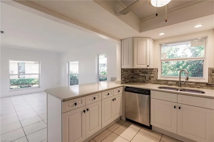 Kitchen featuring stainless steel dishwasher, decorative backsplash, healthy amount of natural light, and recessed lighting