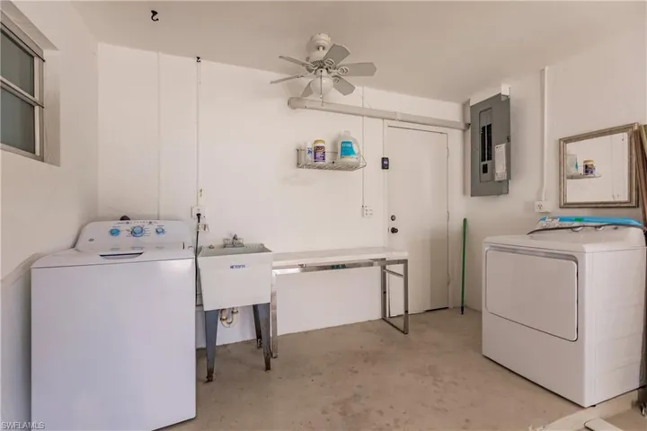 Washroom with electric panel, a ceiling fan, and separate washer and dryer
