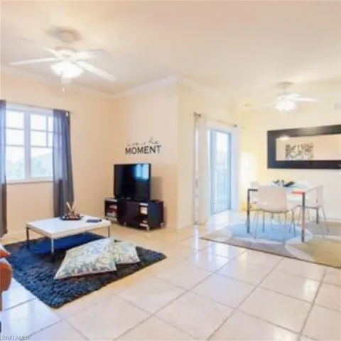 Open concept living and dining area featuring large format tile flooring, crown molding, and recessed lighting
