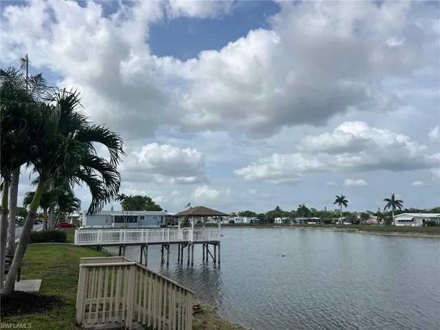 Dock with a gazebo, a water view, and a yard