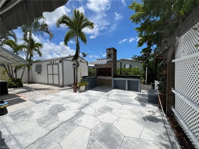 View of patio featuring a storage shed and BBQ