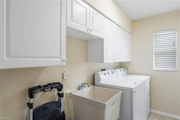 Washroom featuring cabinets, separate washer and dryer, and sink