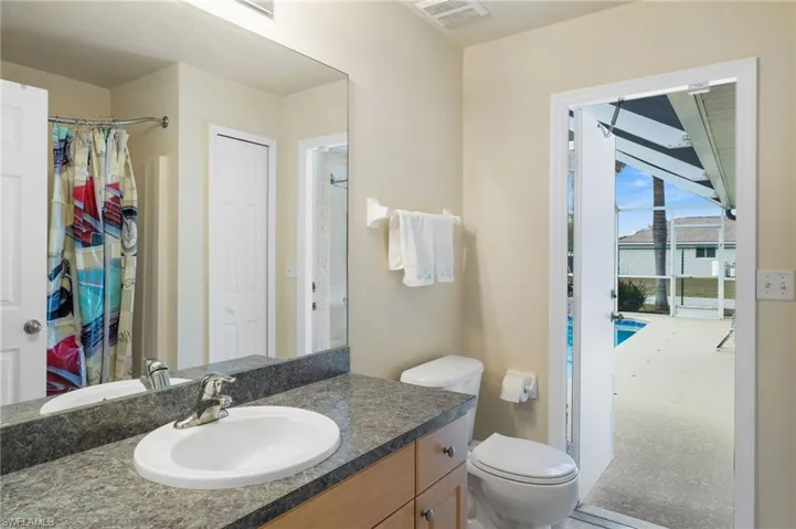 Bathroom with toilet, walk in shower, and vanity