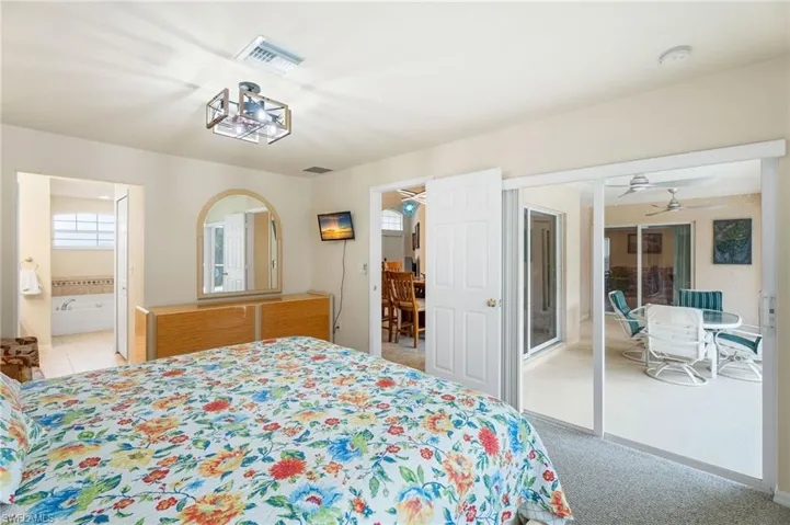 Bedroom featuring a closet, light carpet, and ensuite bath