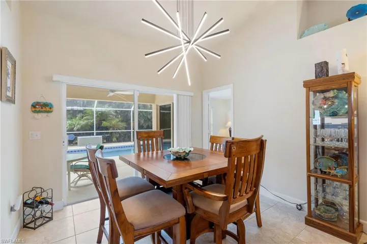 Dining space with light tile patterned floors and a notable chandelier