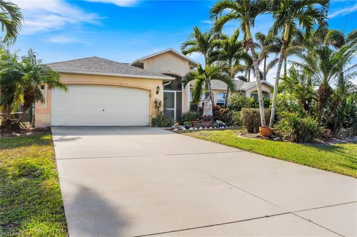 Ranch-style house with a garage and a front lawn