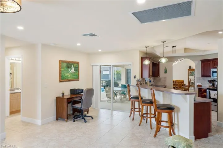 Kitchen featuring kitchen peninsula, a kitchen breakfast bar, decorative light fixtures, tasteful backsplash, and stainless steel appliances