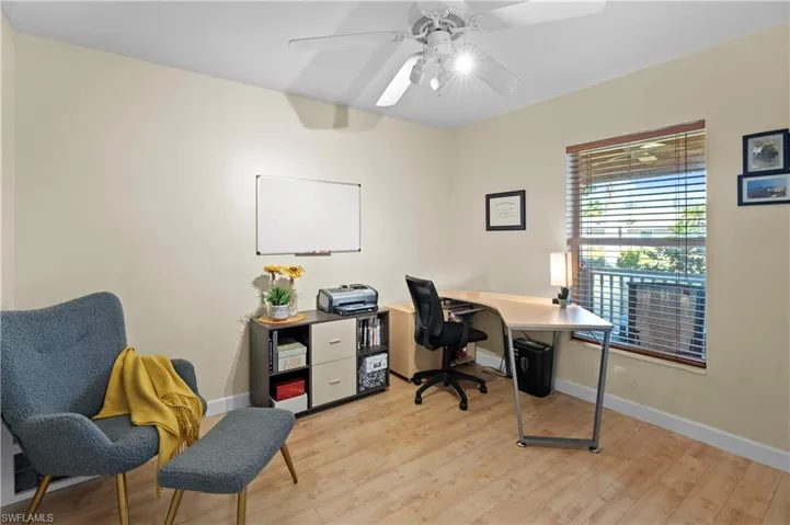 Office area with light wood-style floors and a ceiling fan