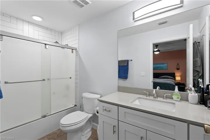 Full bath with enclosed tub / shower combo, vanity, connected bathroom, and ceiling fan