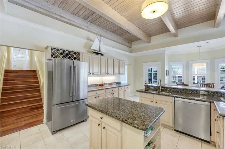 Kitchen features stainless appliances, white cabinets and coastal vibes.